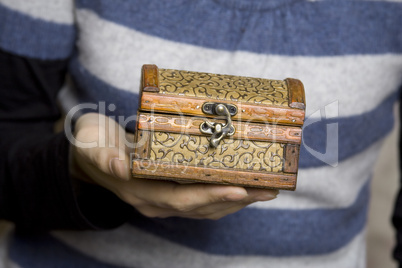 Hands holding a decorative wooden box