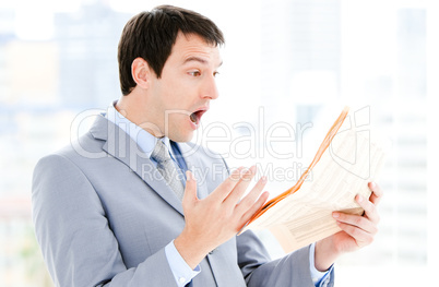 Portrait of a annoyed businessman reading a newspaper