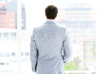 Ambitious businessman looking through a window