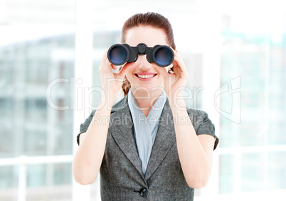 Pretty businesswoman using binoculars