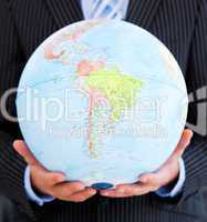 Close-up of a relaxed businessman holding a globe