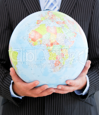 Close-up of a charismatic businessman holding a globe