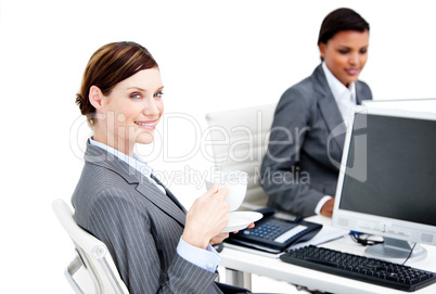 Smiling female business partners having a break drinking coffee