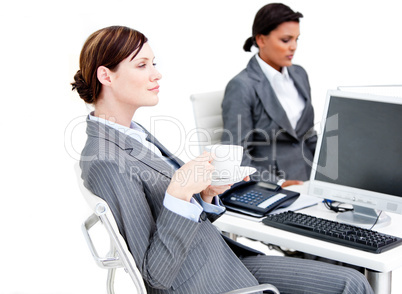 Busy female business partners having a break drinking coffee