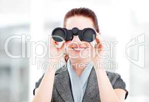 Attractive businesswoman using binoculars