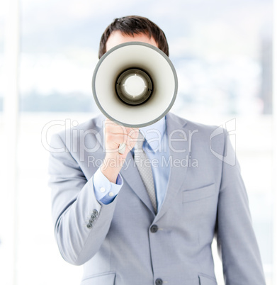 Portrait of an young businessman using a megaphone