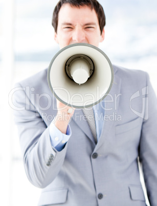 Portrait of an nervous businessman using a megaphone