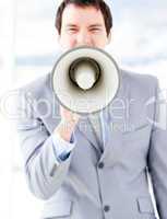 Portrait of an nervous businessman using a megaphone