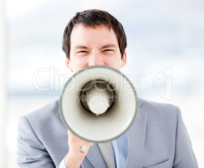 Portrait of an stressed businessman using a megaphone