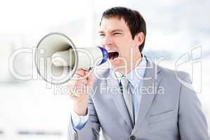 Portrait of an angry businessman using a megaphone