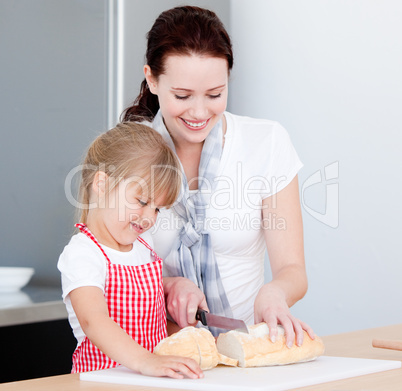 Portrait of a smiling mother and his daughter preparing a meal