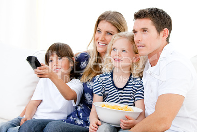Smiling family watching a film at television