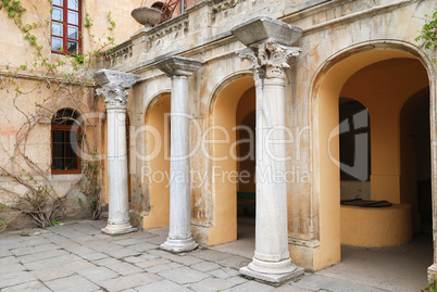 Ancient columns near old building with arches