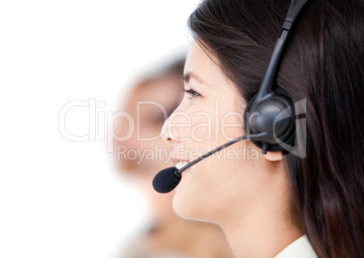 Close-up of business people with headset on standing against a w