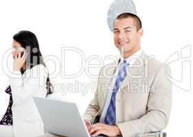 Handsome businessman using a laptop in a waiting room