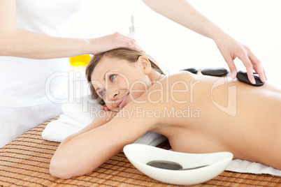 Portrait of a joyful woman having a massage with stones