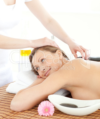 Portrait of a pensive woman having a massage with stones