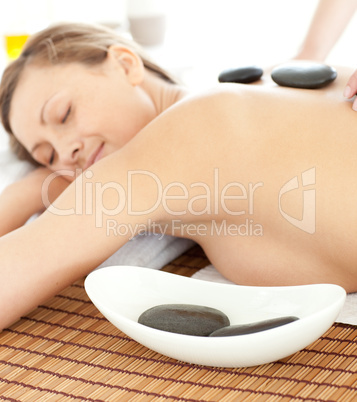 Portrait of a radiant woman having a massage with stones at the