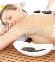 Portrait of a radiant woman having a massage with stones at the