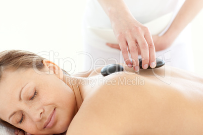 Portrait of a radiant woman having a massage with stones