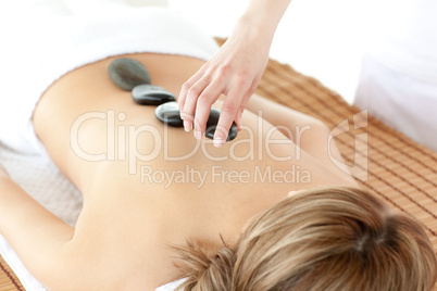 Radiant woman having a stone therapy
