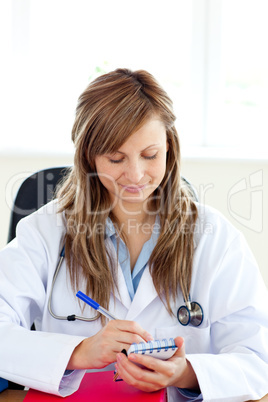 Happy female doctor writing her diagnosis