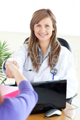 Delighted female doctor shaking a hand