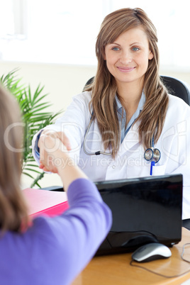 Delighted female doctor shaking a hand