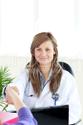 Attractive female doctor shaking a hand