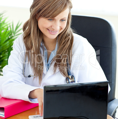Bright female doctor working with a laptop