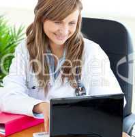 Bright female doctor working with a laptop