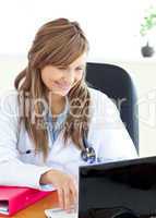 Smiling female doctor working with a laptop