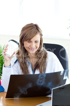 Happy female doctor looking at a radiography