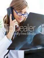 Concentrated female doctor talking on the phone