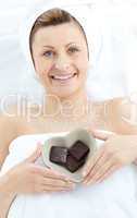 Cheerful woman holding a bowl in the shape of a heart with choco
