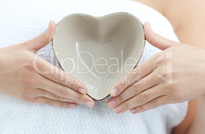 Close-up of a woman holding a bowl in the shape of a heart