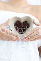 Close-up of a woman holding a bowl in the shape of a heart with