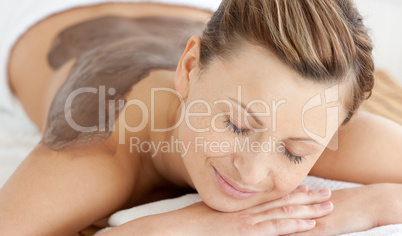 Charming woman enjoying a mud skin treatment