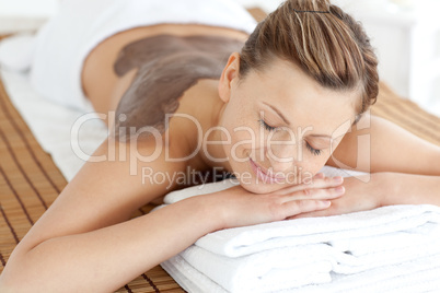 Relaxed woman enjoying a mud skin treatment