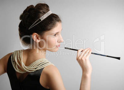 Elegant girl with cigar-holder, side view