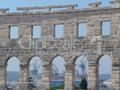 Seaport cranes through Pula Arena