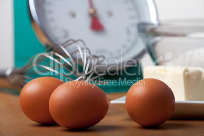 Eier und einen Schneebesen auf einem Holztisch