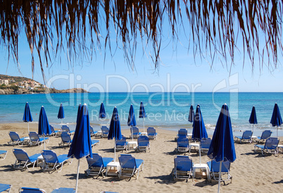 Beach and sunbeds of popular hotel, Crete, Greece