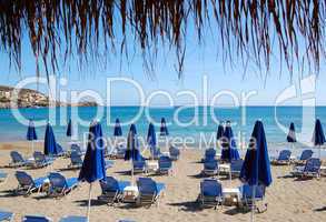 Beach and sunbeds of popular hotel, Crete, Greece