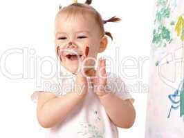 Little girl play with paints, clapping her hands