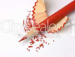 Sharpened red crayon on shavings