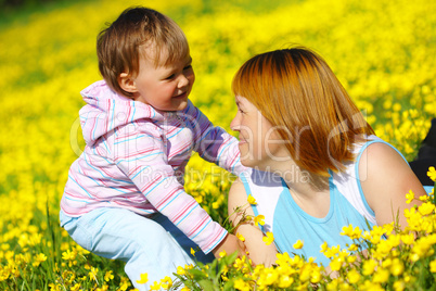 Mother and child play on meadow