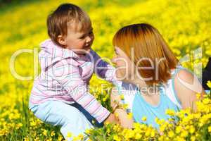 Mother and child play on meadow