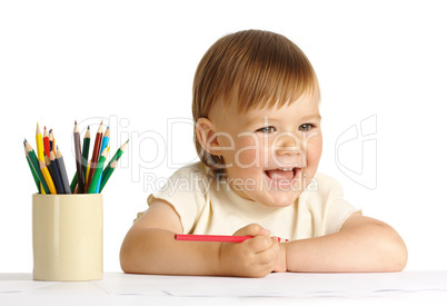 Child draw with red crayon
