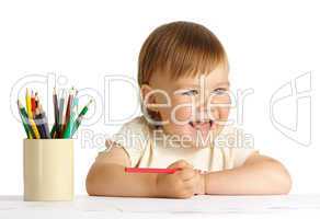 Child draw with red crayon